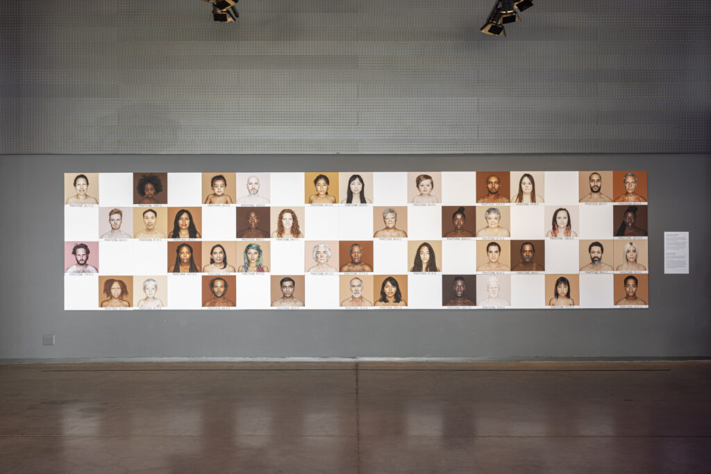 Mosaico de retratos de rostos de pessoas de diversos tons de pele.