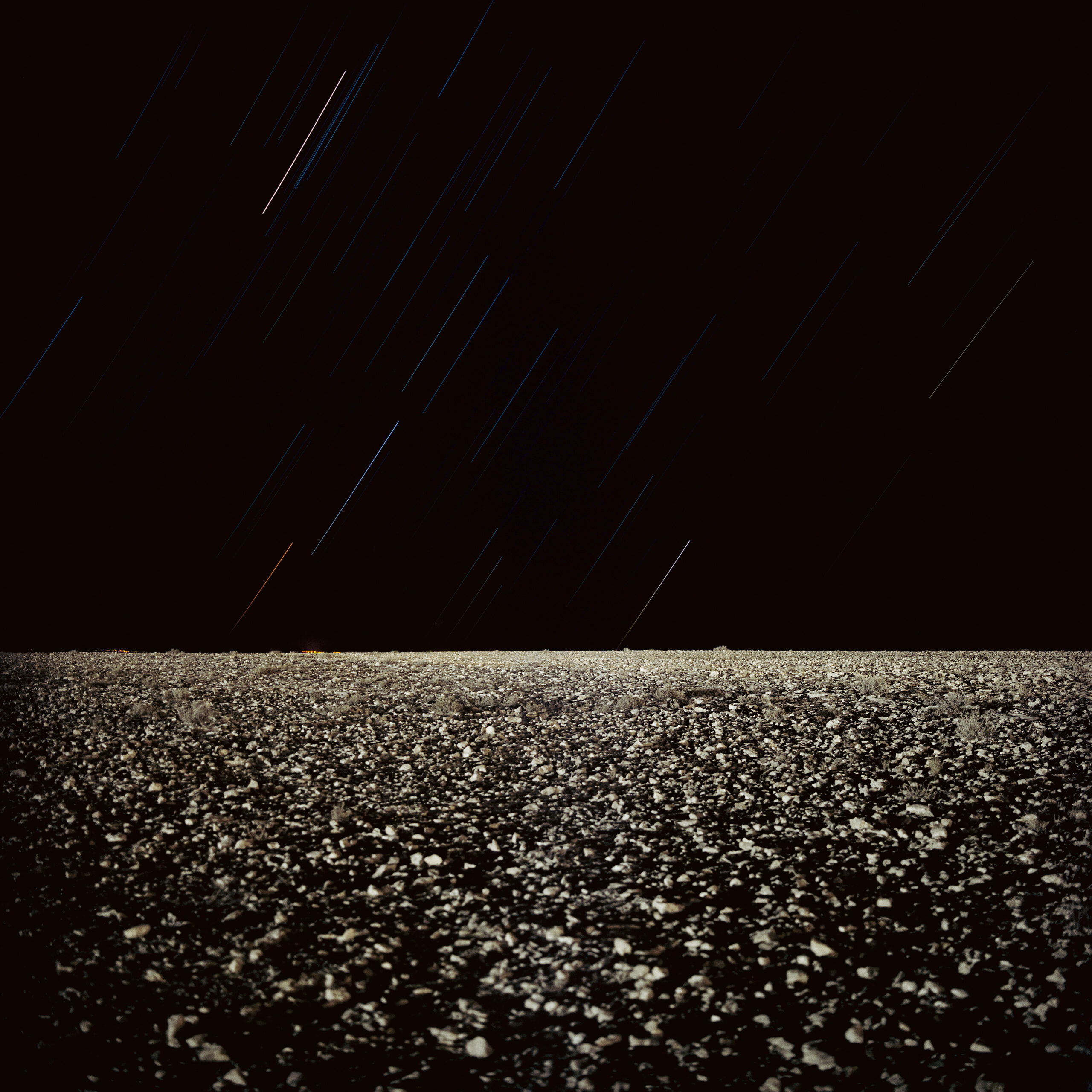 Fotografia noturna de longa exposição em terreno desértico.